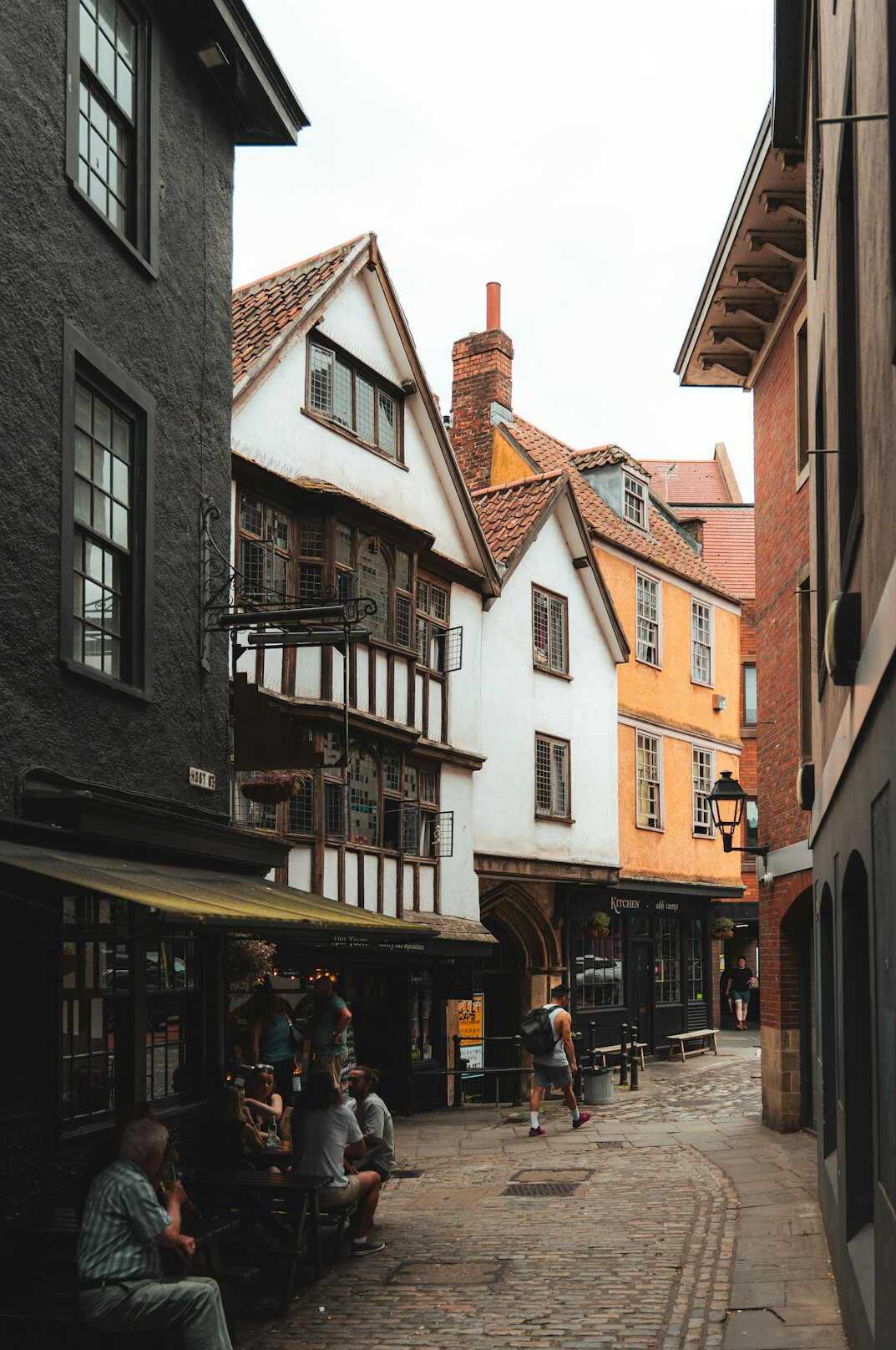 Narrow city street with historic buildings and cafes